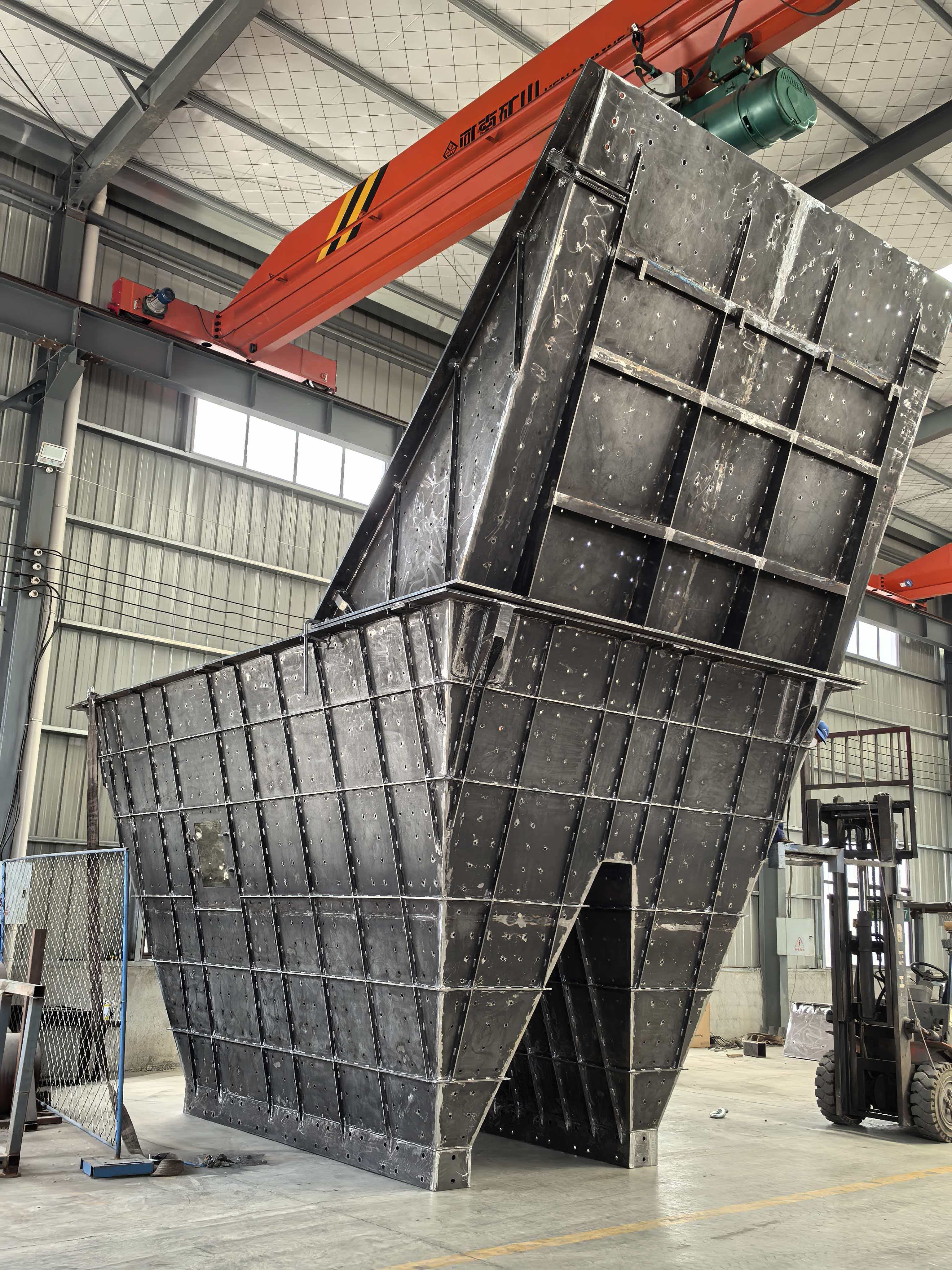 Black welded mining feed hopper during workshop fabrication